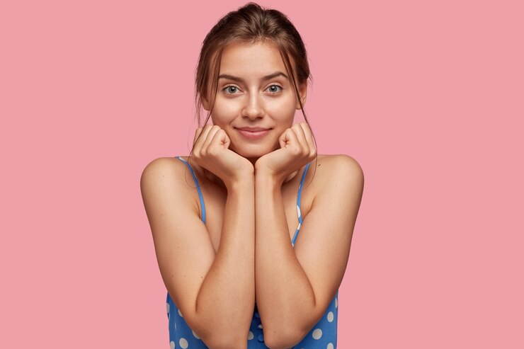 Foto grátis linda e charmosa modelo feminina com as duas mãos embaixo do queixo