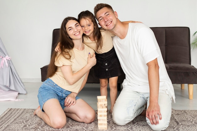 Linda família deitada no chão ao lado de um jogo