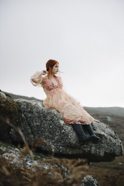 Linda foto vertical de uma mulher ruiva com pele totalmente branca em um lindo vestido rosa