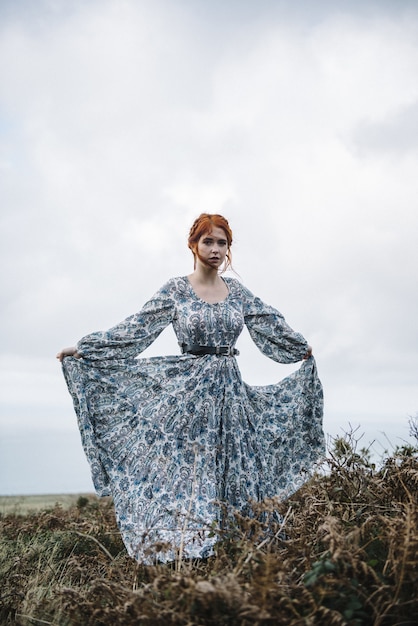 Foto grátis linda foto vertical de uma mulher ruiva com pele totalmente branca em um vestido azul claro