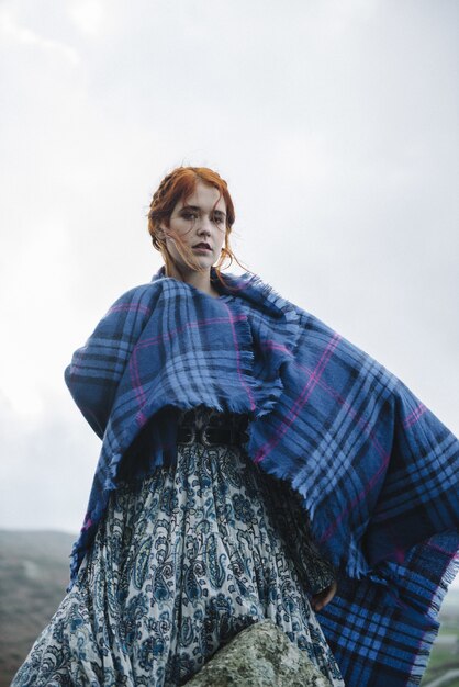 Linda foto vertical de uma mulher ruiva com pele totalmente branca em um vestido leve