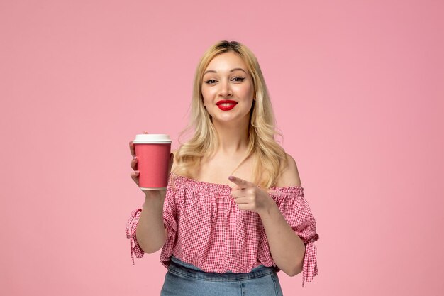 Linda garota adorável jovem com batom vermelho na blusa rosa animada para uma xícara de café