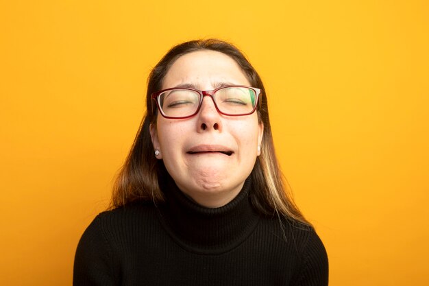 Linda garota chateada em uma gola preta chorando