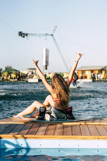 linda garota com cabelo comprido com um wakeboard