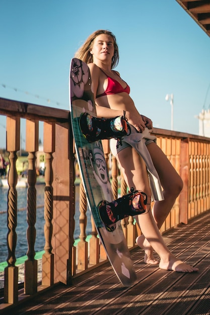 linda garota com cabelo comprido com um wakeboard