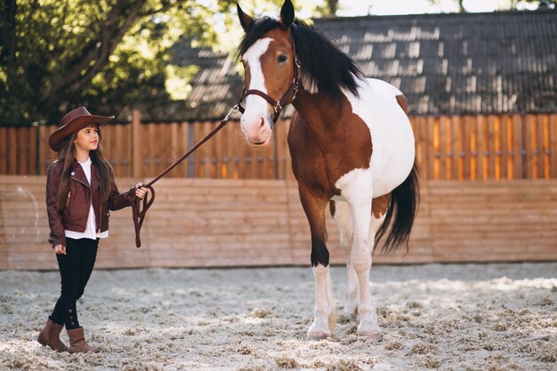 Linda garota com cavalo no rancho