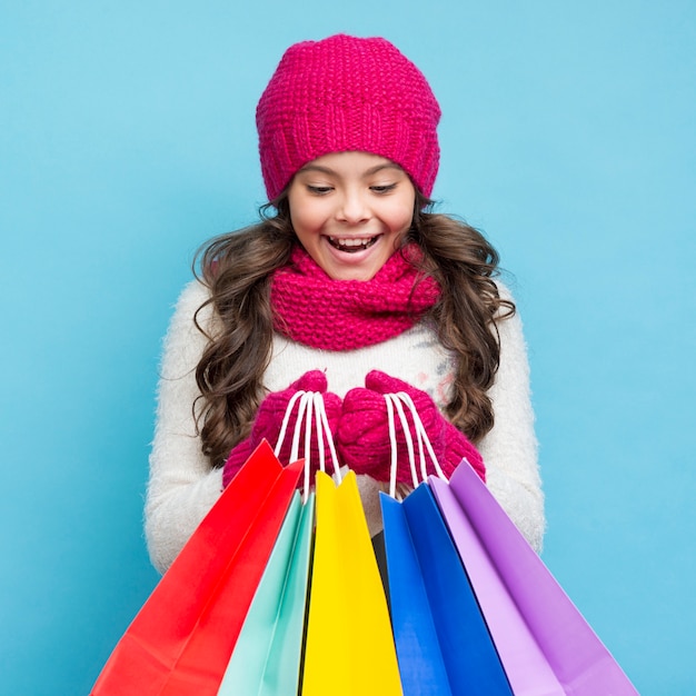 Linda garota com roupas de inverno e sacolas de compras