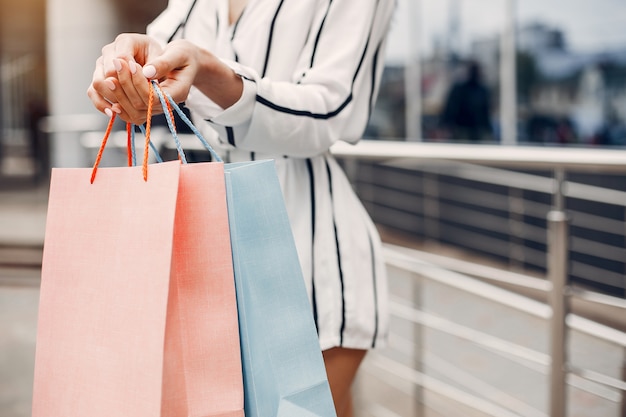 Linda garota com sacola de compras em uma cidade