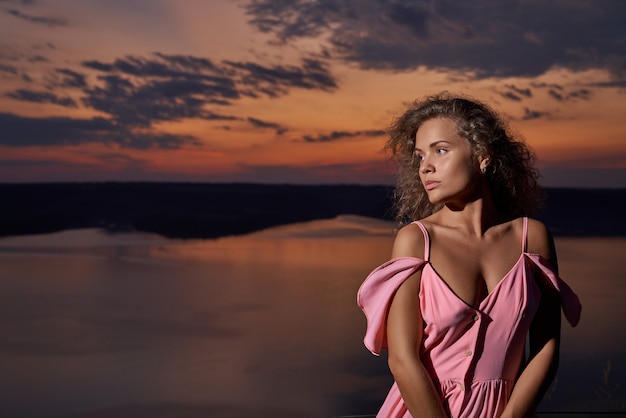 Foto grátis linda garota com um vestido sexy perto do lago à noite