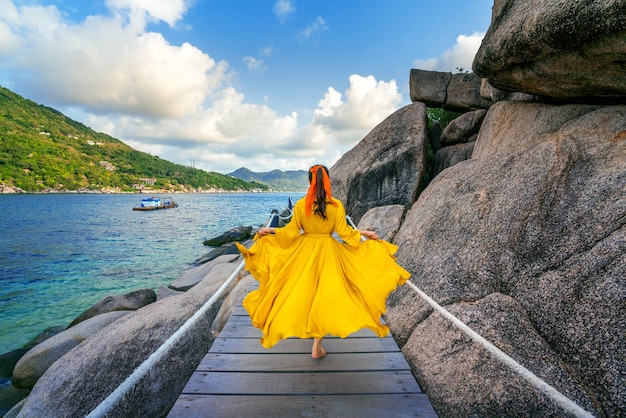 Linda garota correndo em um caminho de madeira na ilha de koh nang yuan, perto da ilha de koh tao, surat thani, na tailândia