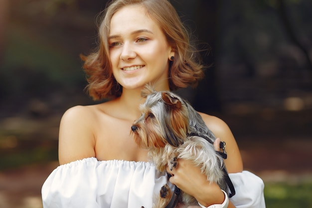 Foto grátis linda garota de blusa branca, brincando com cachorro