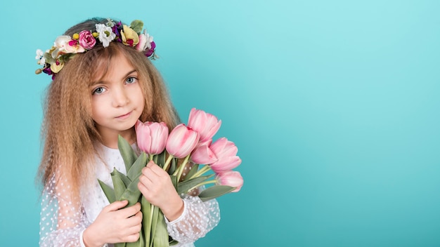 Linda garota de pé com flores tulipa