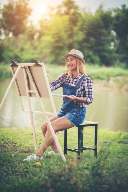 Linda garota desenha uma foto no parque