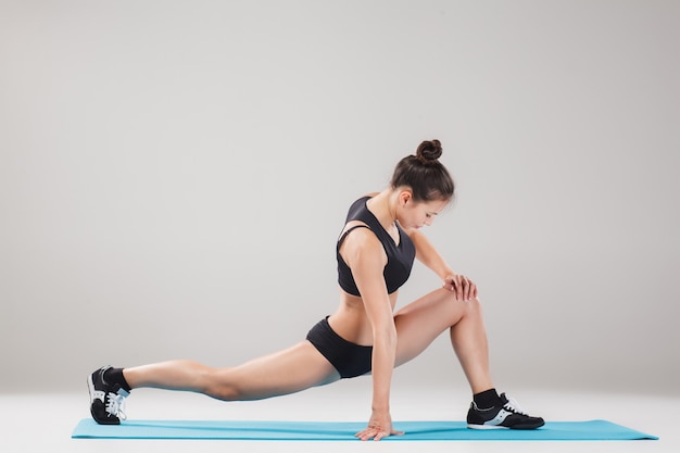 Linda garota desportiva em pé em pose de acrobata