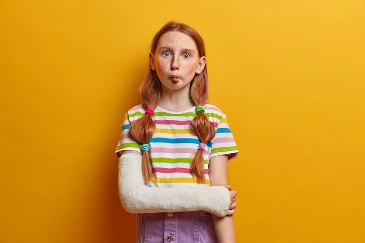 Foto grátis linda garota engraçada com olhos esbugalhados, imita peixes e mantém os lábios dobrados, tem humor brincalhão, não tem medo de mostrar emoções, faz bagunça, quebrou o braço, usa roupas casuais de verão.