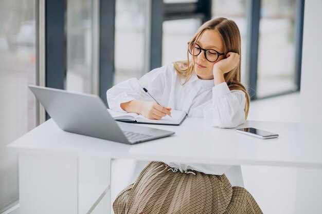 Linda garota estudando no computador em casa