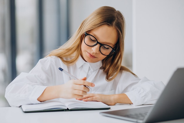 Linda garota estudando no computador em casa