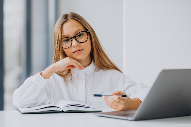 Linda garota estudando no computador em casa