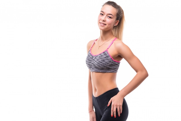 Linda garota fitness mostra seu corpo musculoso e forte em branco