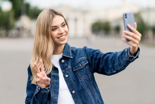 Linda garota loira tirando uma selfie