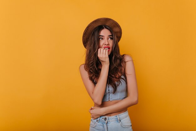 Linda garota morena com pele bronzeada expressando emoção de medo