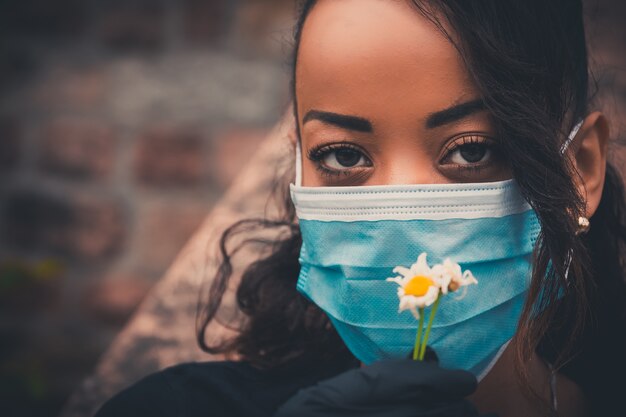 Linda garota negra ao ar livre com uma máscara médica