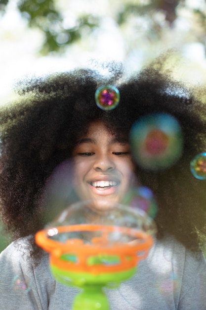 Linda garota negra brincando com bolhas de sabão