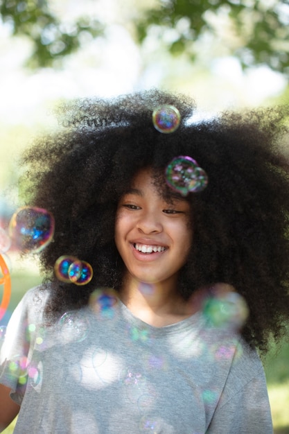 Foto grátis linda garota negra brincando com bolhas de sabão