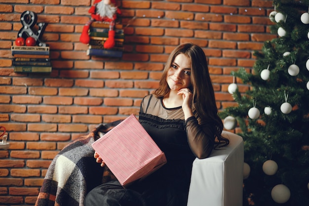 Linda garota se senta em uma sala de Natal