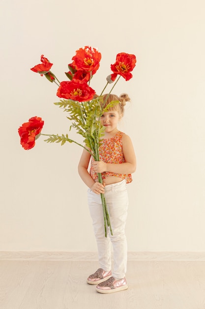 Linda garota segurando grandes flores vermelhas