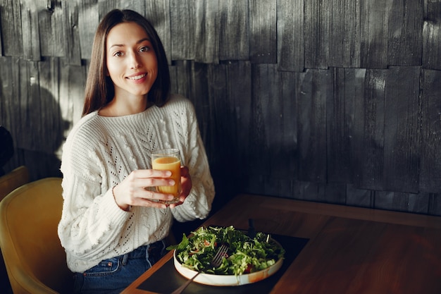 Linda garota sentada em um café