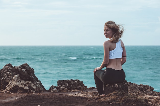 Foto grátis linda garota sentada em um penhasco