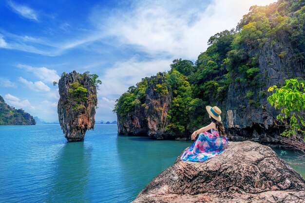 Linda garota sentada na rocha na ilha de James Bond em Phang nga, Tailândia.