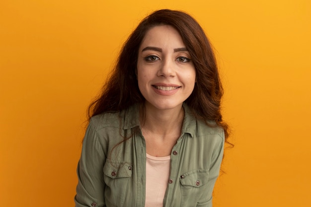 Linda garota sorridente com camiseta verde oliva isolada na parede amarela