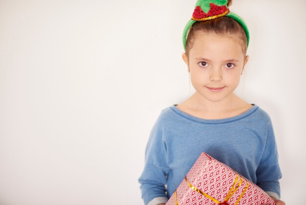 Linda garota usando fantasia de duende com presente de Natal