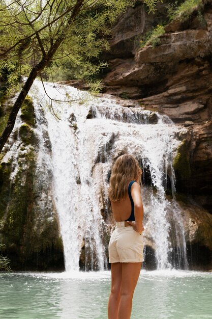 Linda jovem adulta perto da cachoeira