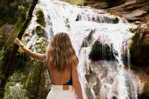 Foto grátis linda jovem adulta perto da cachoeira