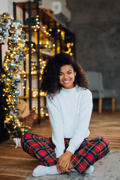 Linda jovem afro-americana no chão rosto feliz sorrindo e olhando para a câmera Pessoa positiva