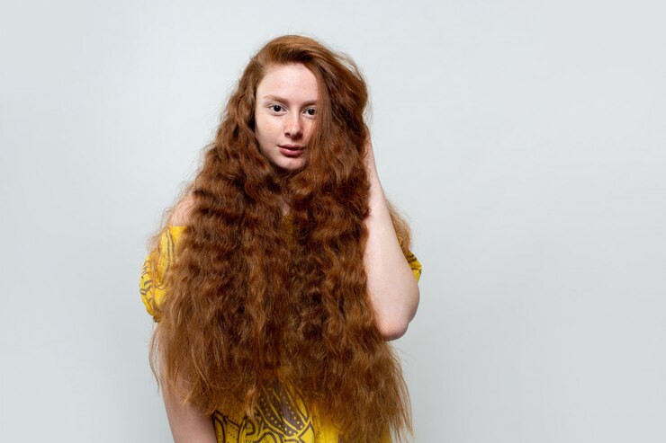Foto grátis linda jovem com longos cabelos ruivos vestido amarelo na cinza