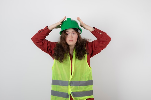 Foto grátis linda jovem em pé no colete e usando um capacete.