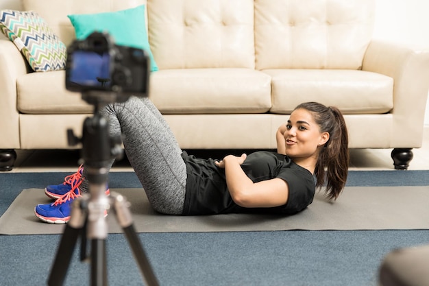 Foto grátis linda jovem treinadora de fitness e blogueira dando alguns conselhos de treino na câmera