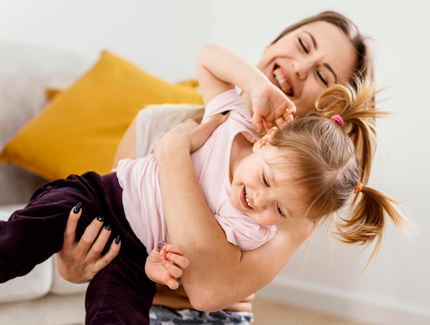 Linda mãe brincando com a filha em casa