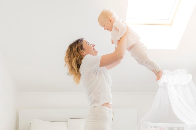 Linda mãe brincando com bebê em casa