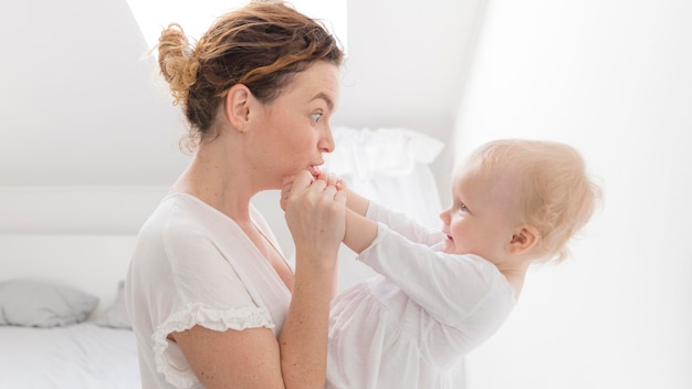 Linda mãe brincando com bebê fofo