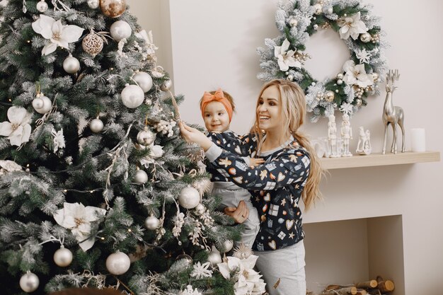 Linda mãe com filho. Família na atmosfera do cristmas. Pessoas usando árvore de Natal.