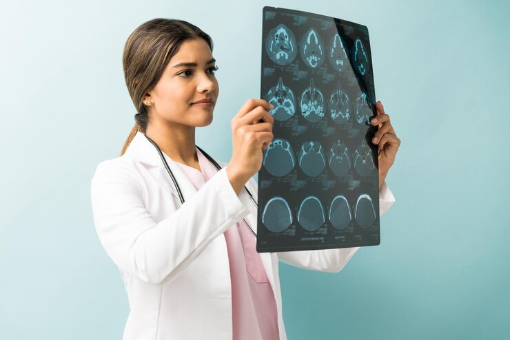 Foto grátis linda médica examinando raio-x em pé no estúdio