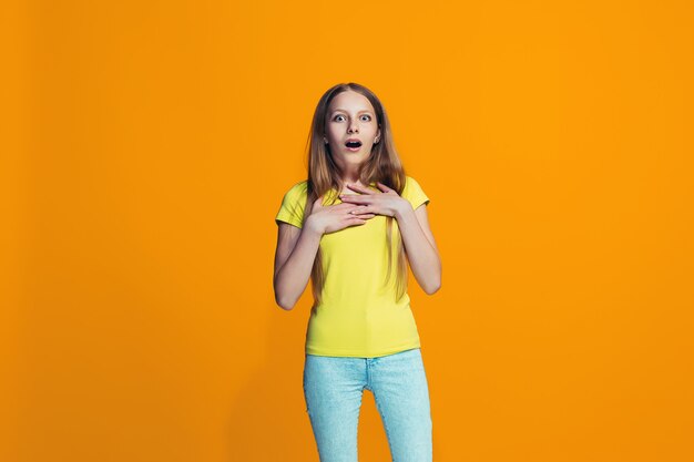 Linda menina adolescente olhando surpreso isolado na laranja