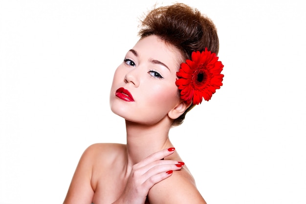 Linda menina com flor de lábios vermelhos no cabelo