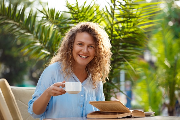 Linda menina sentada no café.