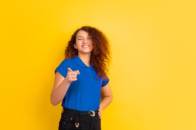 Linda modelo feminino encaracolado com camisa apontando